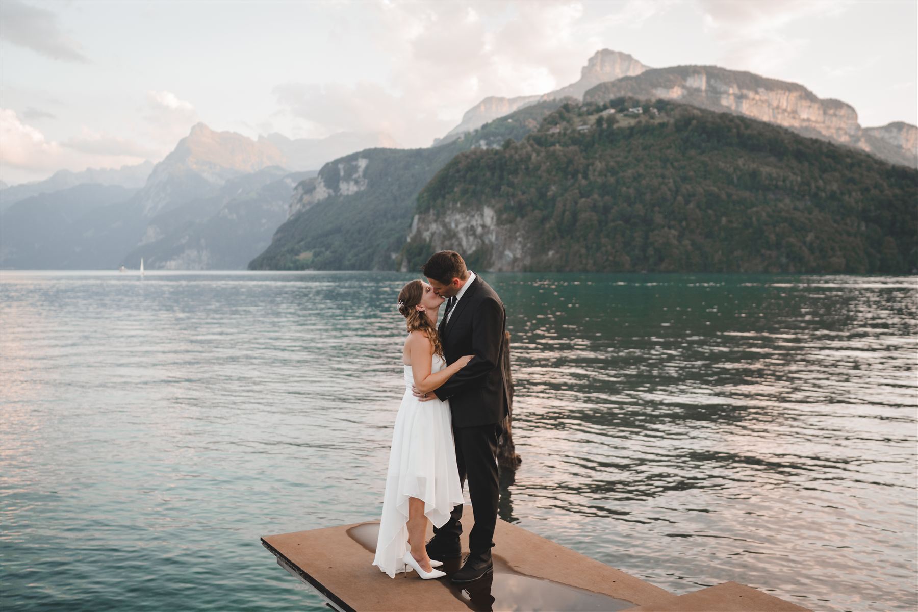 Anja und Raphi küssen sich auf einem Steg am See